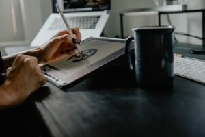 Designer sketching on a tablet with a stylus at a desk