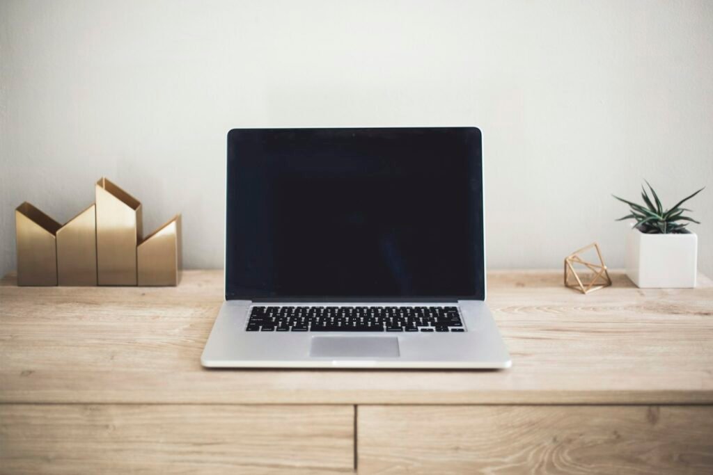 MacBook on a wooden desk in a bright workspace